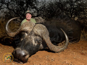 Hunter kneeling behind his trophy on a cape buffalo safari